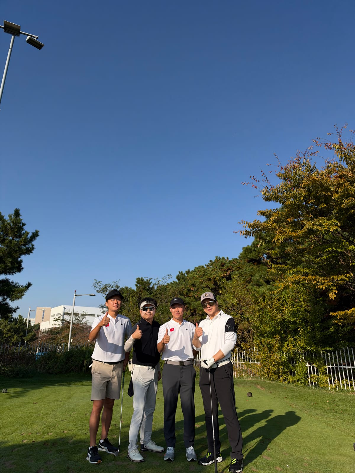 Golfers on the tee giving a thumbs up