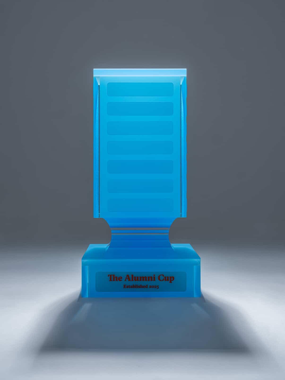 The Alumni Cup trophy, front view, lit against a dark background
